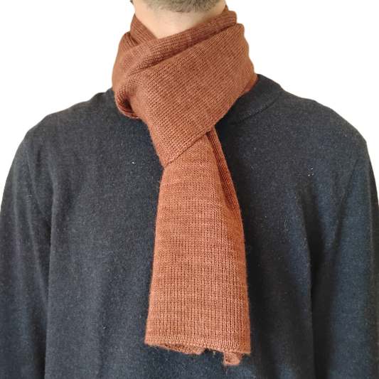A close-up of a person wearing a brown knit scarf over a dark charcoal sweater, against a plain white background.