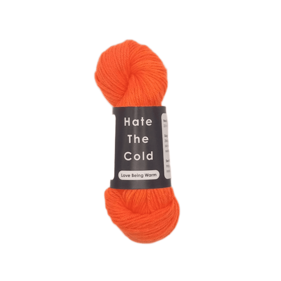 Orange skein of yarn with a label reading ' Hate The Cold' on a white background