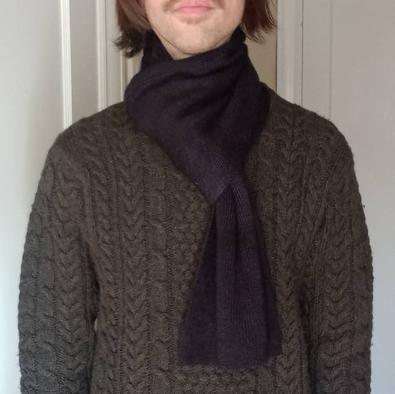 100% baby alpaca scarf in black on a model