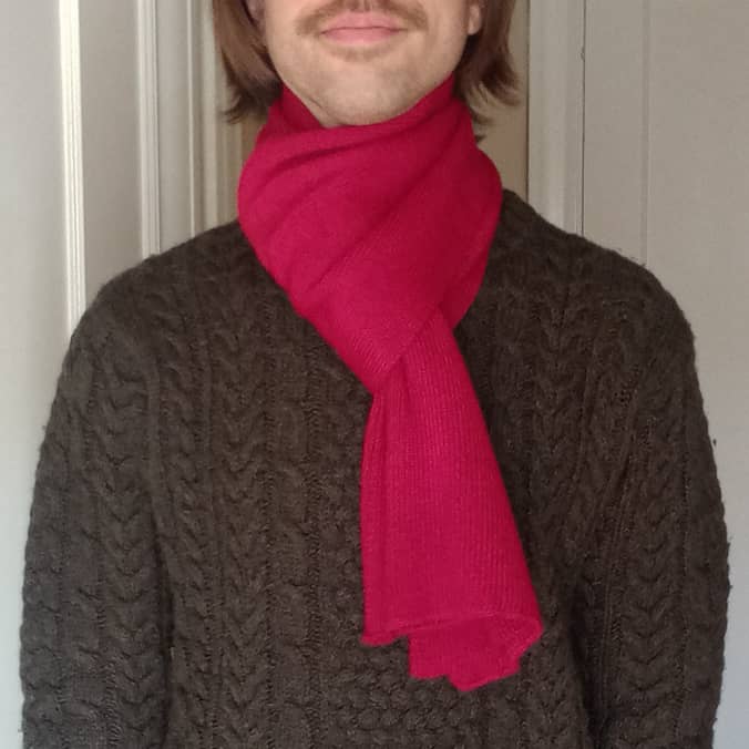 100% baby alpaca scarf in red on a model
