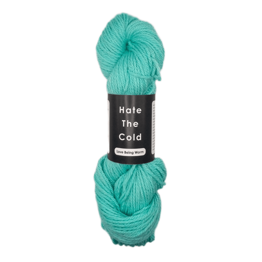 Turquoise skein of yarn with a label on a white background