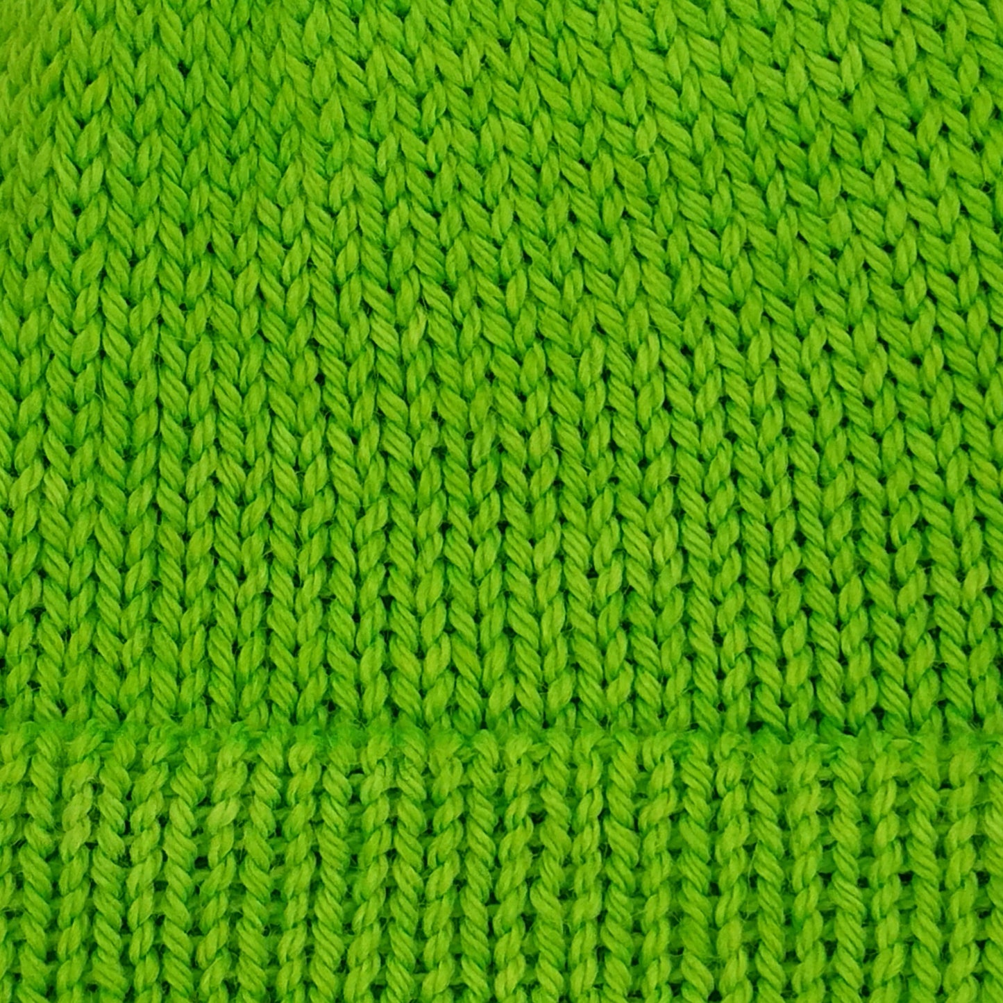 Close-up of a bright lime green knitted fabric texture.