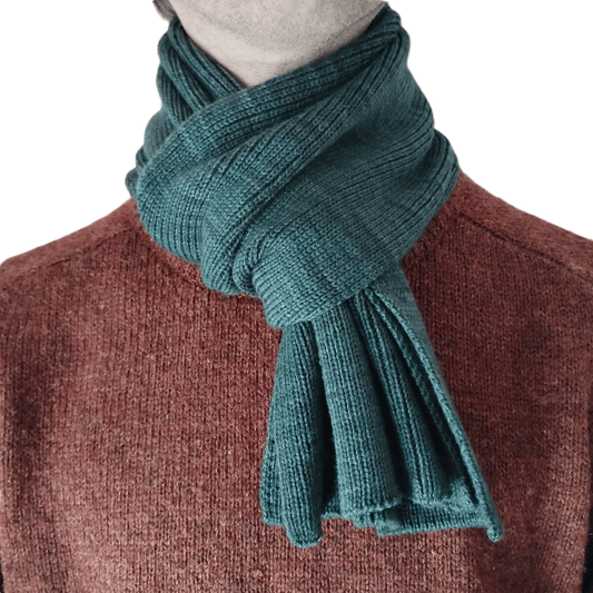 A forest green knit merino wool scarf on a model.