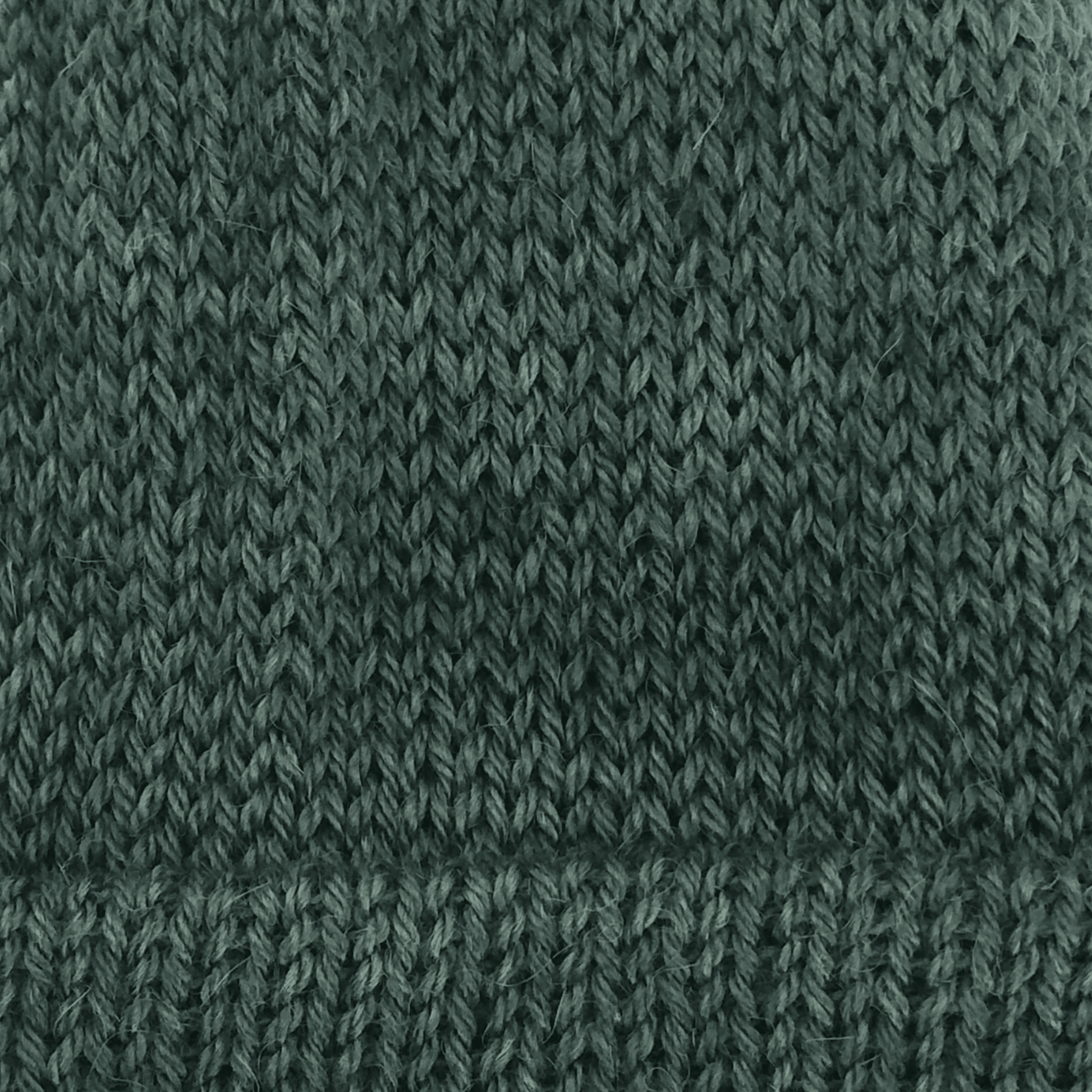 Close-up of a dark green knit alpaca in worsted weight.