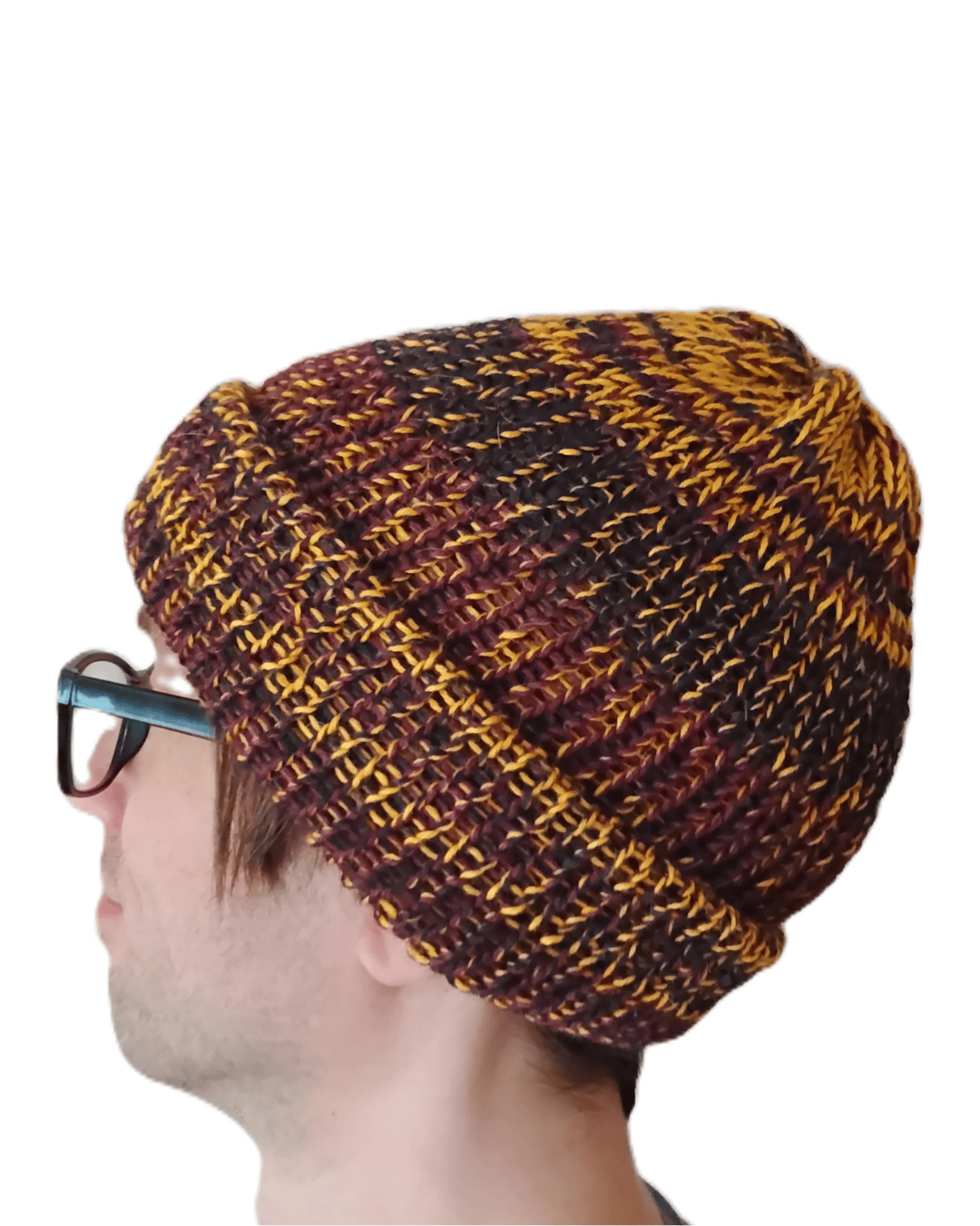 This is a 100% baby alpaca beanie in charcoal, yellow, and maroon on a model.