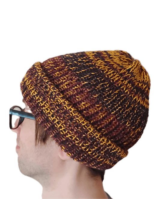 This is a 100% baby alpaca beanie in charcoal, yellow, and maroon on a model.