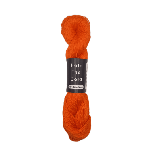 Orange skein of yarn with a label on a white background